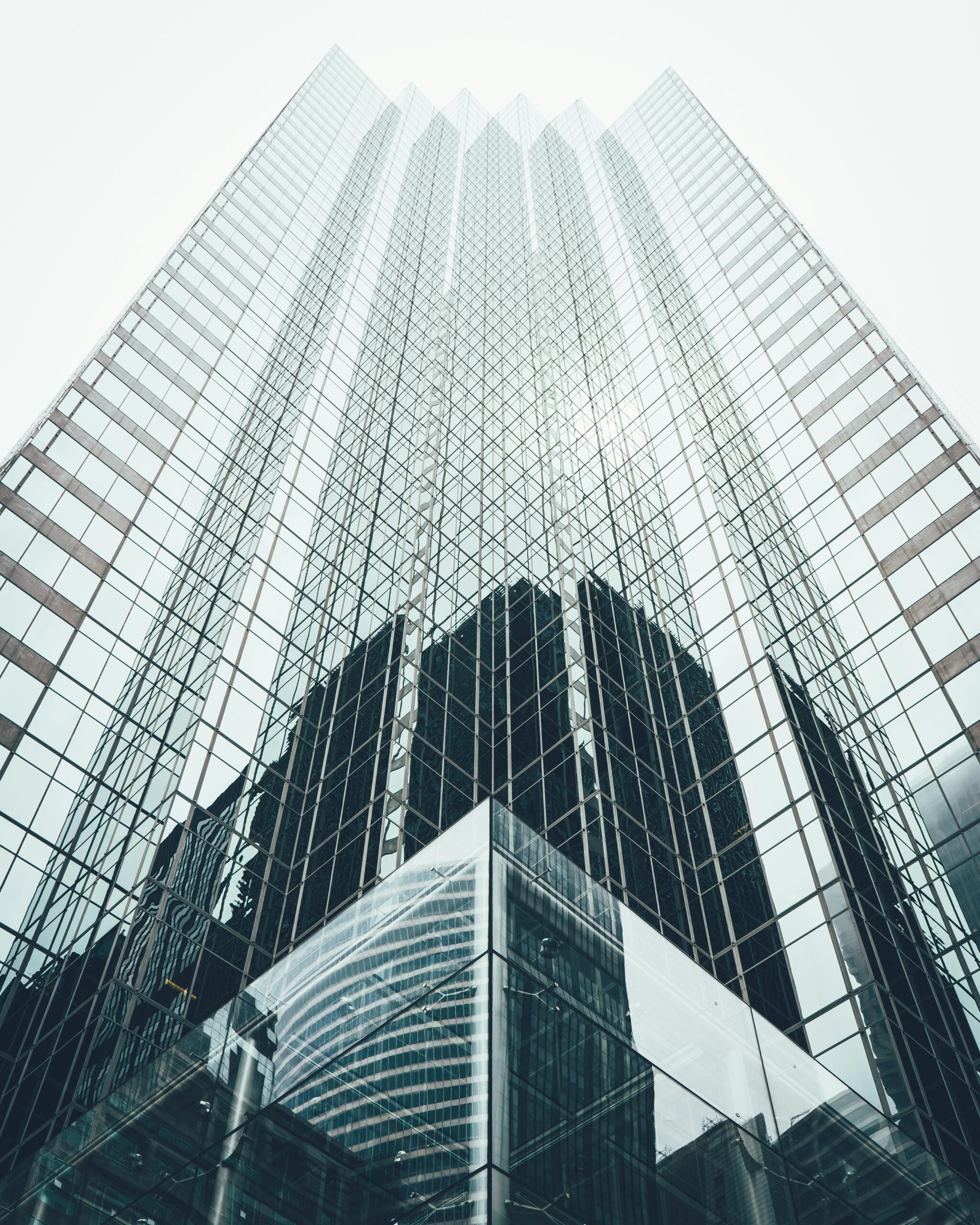 Striking low angle view of a modern skyscraper with reflective glass facade in a cityscape.